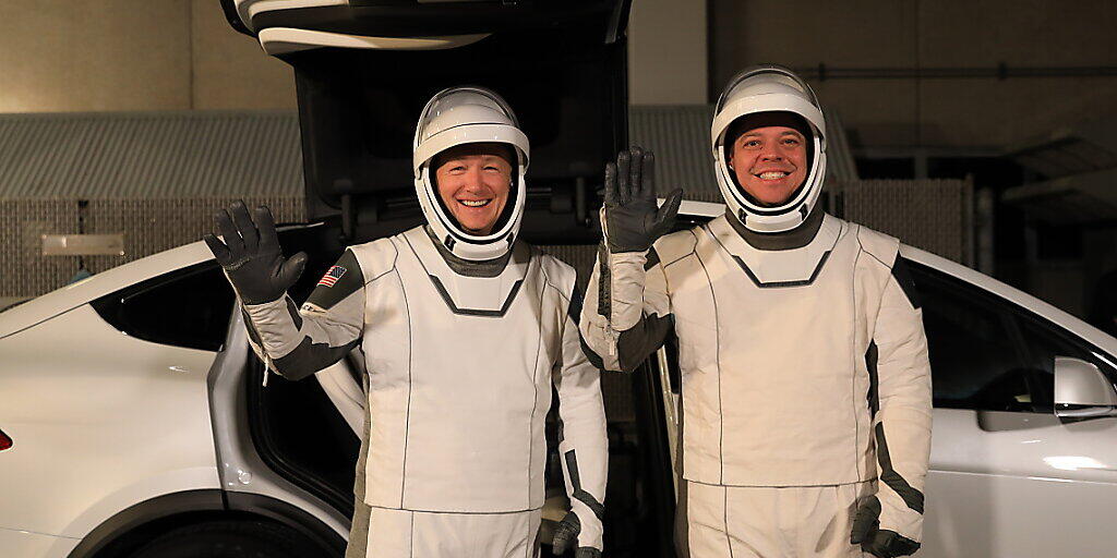Die Astronauten Doug Hurley (links) und Bob Behnken vor einem Tesla-Elektroauto im Kennedy Space Center in Florida. (Archivbild)