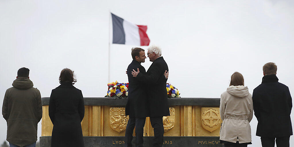 Macron (l.) und Steinmeier umarmen sich brüderlich als Zeichen der deutsch-französischen Verbundenheit: Gemeinsam weihten sie im Elsass ein Museum ein zum Gedenken der Opfer des Ersten Weltkriegs.