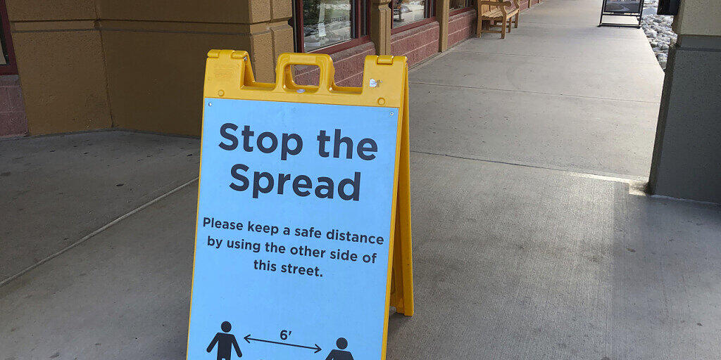 ARCHIV - Ein Schild vor einem Einkaufszentrum weist Kunden darauf hin, Abstand zu halten, um die Verbreitung des Coronavirus einzudämmen. Foto: David Zalubowski/AP/dpa ARCHIV - Ein Schild vor einem Einkaufszentrum weist Kunden darauf hin, Abstand zu halten, um die Verbreitung des Coronavirus einzudämmen. Foto: David Zalubowski/AP/dpa
