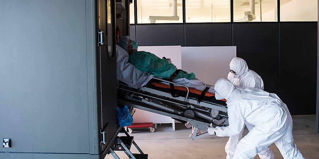 Das Tessin ist landesweit am stärksten vom Coronavirus betroffen: Soldaten der Schweizer Armee beim Transport eines Patienten mit Covid-19 am Eingang der Notaufnahme im Kantonsspital ''La Carita'' in Locarno.