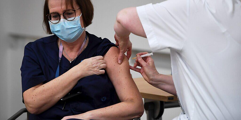 Eine Krankenpflegerin erhält in der Universitätsklinik Helsinki den Corona-Impfstoff von Biontech/Pfizer. Foto: Antti Aimo-Koivisto/Lehtikuva/dpa Eine Krankenpflegerin erhält in der Universitätsklinik Helsinki den Corona-Impfstoff von Biontech/Pfizer. Foto: Antti Aimo-Koivisto/Lehtikuva/dpa