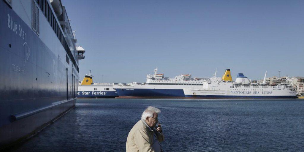 Ein Fährmann raucht vor stillstehenden Fähren im Hafen von Piräus. Die griechischen Seeleute protestieren mit dem Streik gegen die Kürzung ihrer Renten