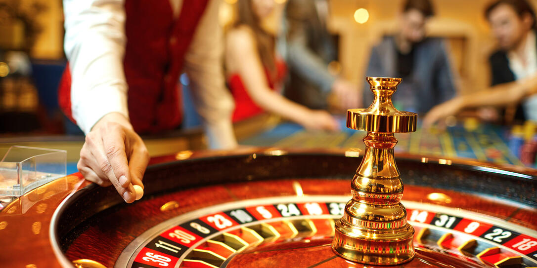The croupier holds a roulette ball in a casino in his hand. The croupier holds a roulette ball in a casino in his hand.