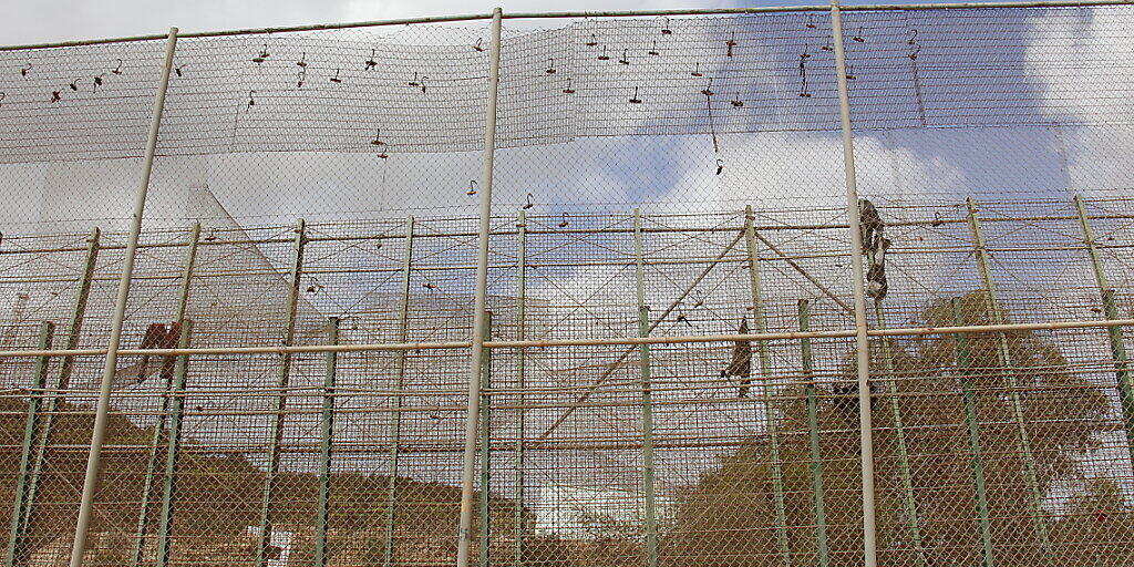 ARCHIV - Nach einem Migranten-Ansturm hängen Kleiderfetzen am Grenzzaun von Melilla. Foto: Europapress/dpa