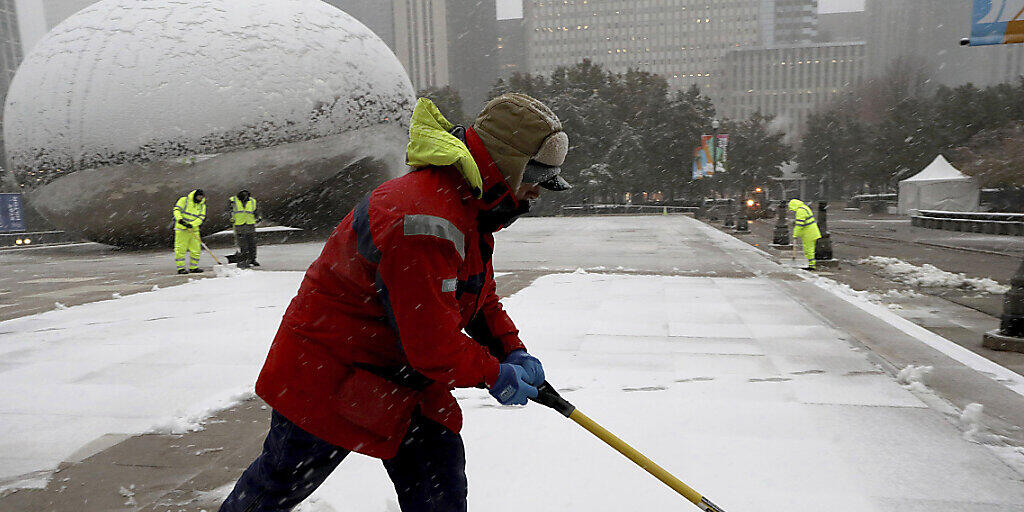 Strassenarbeiter beim Schneeschaufeln in Chicago am Montagmorgen. Dem heftigen Schneefall fielen am internationalen Flughafen hunderte Flüge zum Opfer.