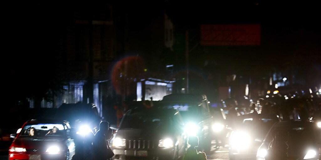 Passanten in Caracas überqueren einen Fussgängerstreifen im Dunkeln, nachdem wegen eines landesweiten Blackouts auch die Strassenbeleuchtung ausgefallen war.