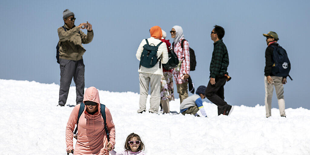 Touristen geniessen die sommerlichen Temperaturen auf dem Titlis im Schnee: Im Juli haben erneut mehr Ausländer hierzulande übernachtet. Besonders die Lust der Amerikaner, die Schweiz zu bereisen, nimmt zu. (Symbolbild)