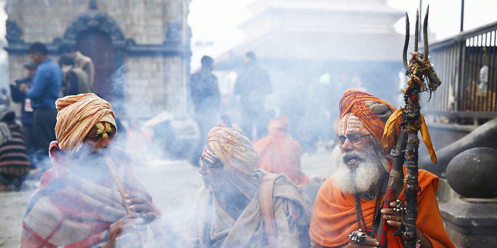Vor dem Pashupati-Tempel in Kathmandu versammeln sich Sadhus - als heilig angesehene Männer -, um dort die ganze Nacht zu beten und zu meditieren.