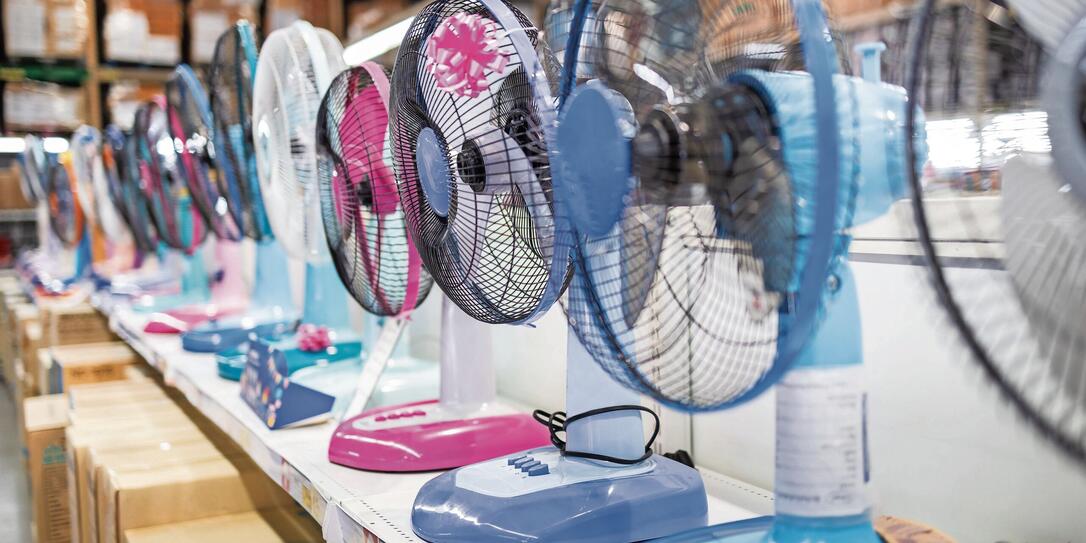 Fan for cooling in an electronics shop,various brands of electrical fans display on a shelf at supermarket in sunny hot summer day,choosing to buy energy efficient appliances,save energy concept