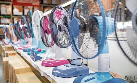 Fan for cooling in an electronics shop,various brands of electrical fans display on a shelf at supermarket in sunny hot summer day,choosing to buy energy efficient appliances,save energy concept
