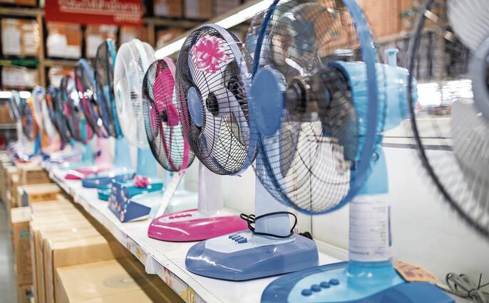 Fan for cooling in an electronics shop,various brands of electrical fans display on a shelf at supermarket in sunny hot summer day,choosing to buy energy efficient appliances,save energy concept