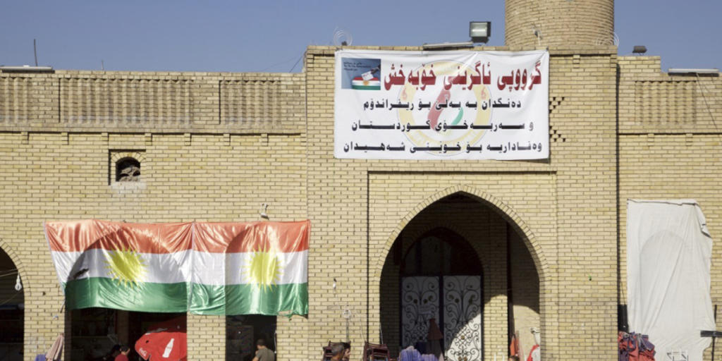 Eine kurdische Flagge und ein Abstimmungsplakat, das zu einem Ja beim Unabhängigkeitsreferendum in der autonomen Kurdenregion im Nordirak aufruft.