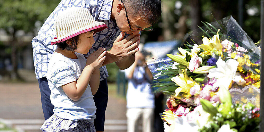 Ein Mann und seine Tochter beten für die Opfer des amerikanischen Atombombenabwurfs vor 75 Jahren. Foto: Takuto Kaneko/Kyodo News/AP/dpa