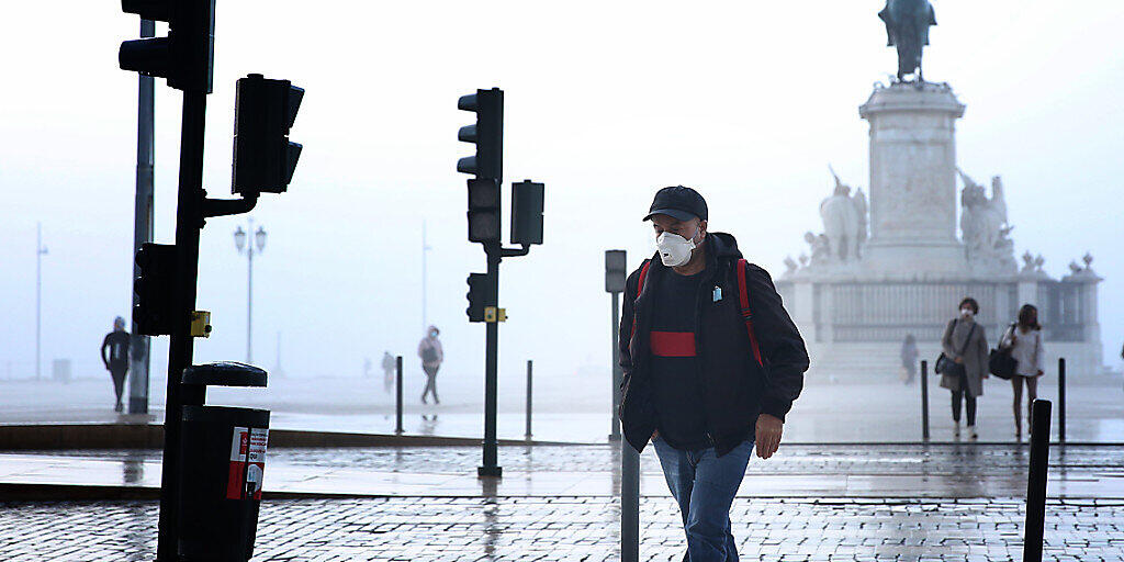 Ein Mann mit Mund-Nasen-Schutz geht durch Lissabon. Foto: Pedro Fiuza/ZUMA Wire/dpa Ein Mann mit Mund-Nasen-Schutz geht durch Lissabon. Foto: Pedro Fiuza/ZUMA Wire/dpa