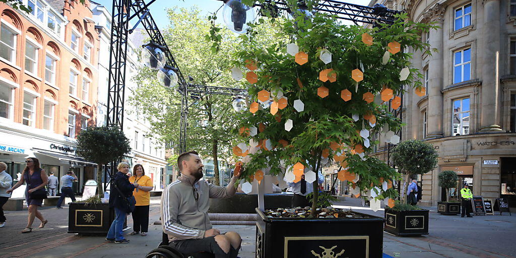 Ein Opfer des Terroranschlags von Manchester liest Nachrichten, die an einem "Baum der Hoffnung" auf dem St Ann's Square in Manchester hinterlassen wurden.