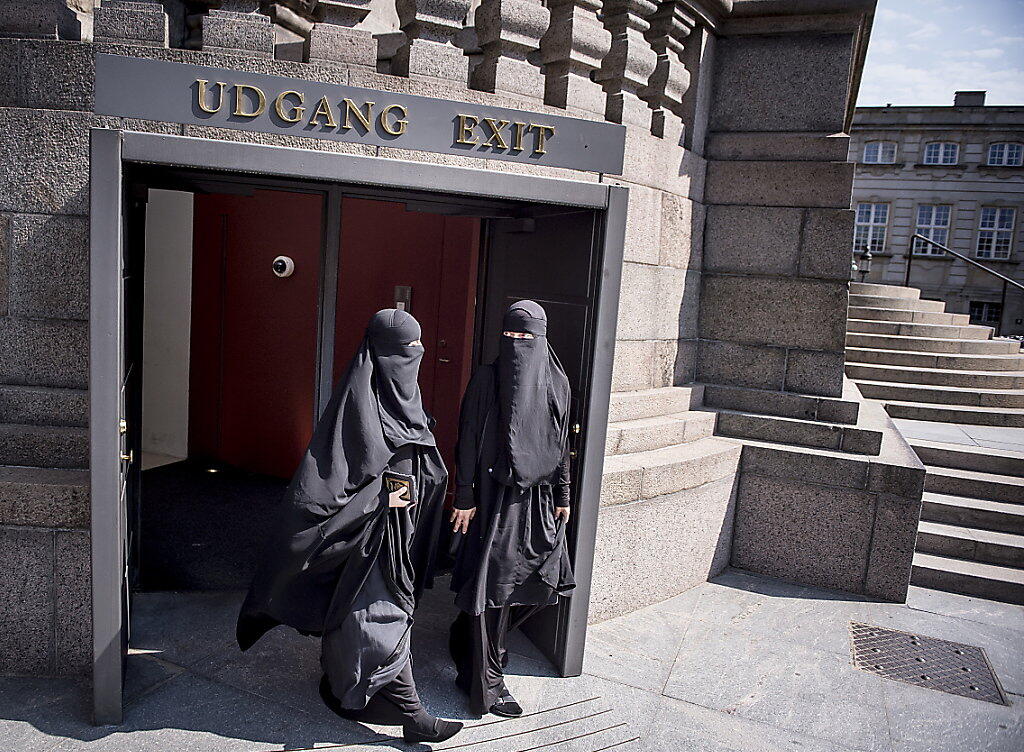 Zwei Nikab-tragende Frauen verlassen das dänische Parlament, nachdem dieses das Verbot der Vollverschleierung beschlossen hat. (Archiv)