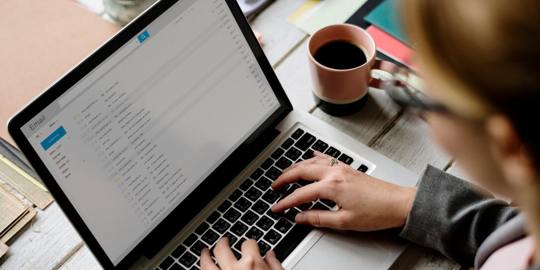 Businesswoman Checking E-mail Online on Laptop