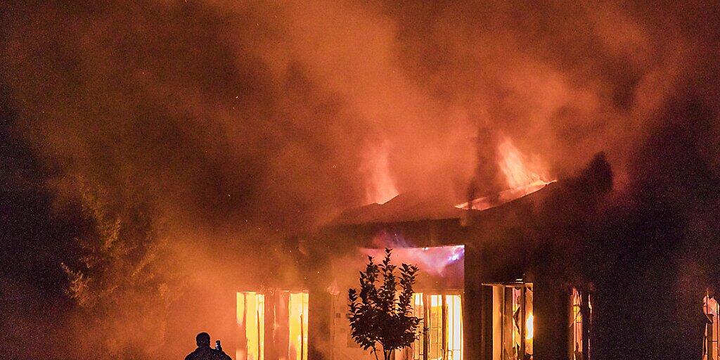 dpatopbilder - Ein Mann fotografiert mit einem Handy den Brand eines Gebäudes, nach dem Einschlag einer aserbaidschanischen Rakete. Foto: Celestino Arce Lavin/ZUMA Wire/dpa