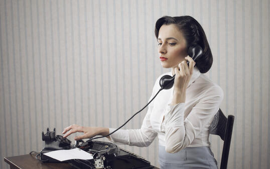 Woman talking on phone at desk