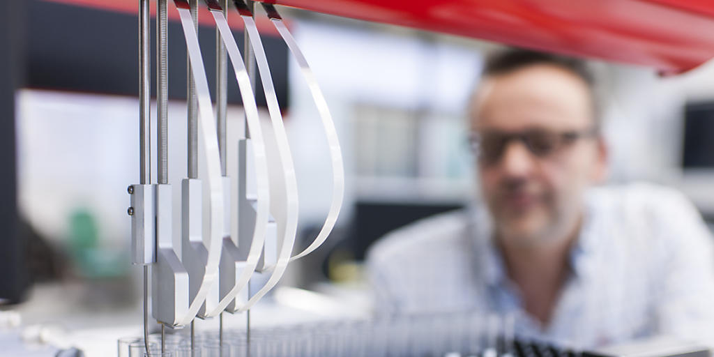 Ein Mitarbeiter der Firma Sias testet einen Pipettierroboter. Die Firma wird vom Laborausrüster Tecan übernommen.