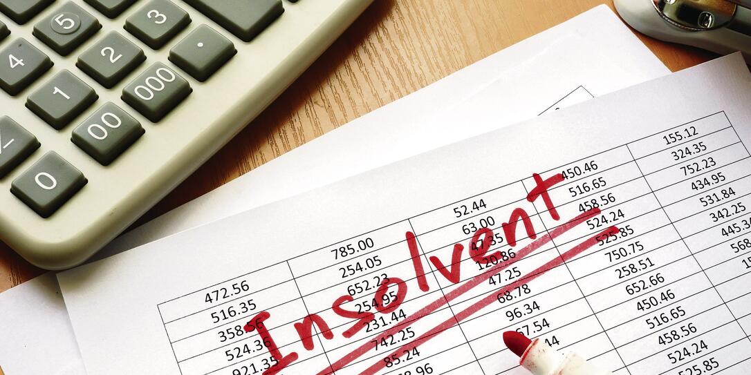 Insolvent written on a paper with financial figures. Insolvent written on a paper with financial figures.