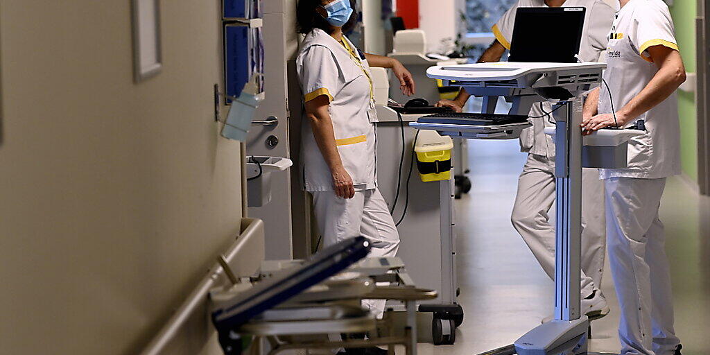 Krankenhauspersonal mit Mund-Nasen-Bedeckung bereitet in Bonheiden die Öffnung einer zusätlich eingerichteten Intensivstation vor. Foto: Dirk Waem/BELGA/dpa