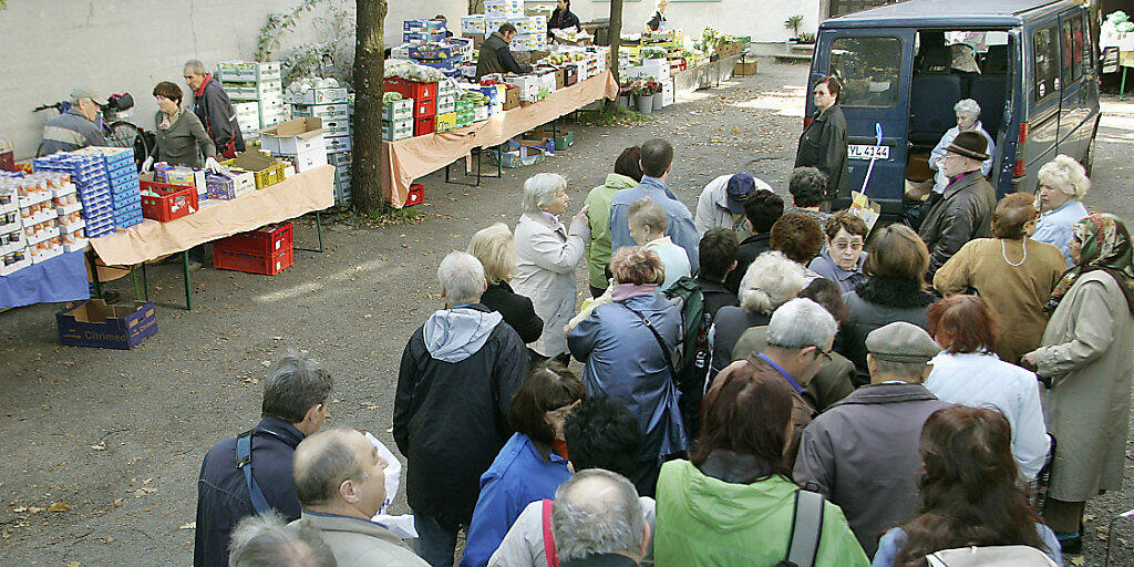 Bedürftige Menschen stehen beim gemeinnützigen Verein "Münchner Tafel" Schlange und warten auf die Verteilung kostenloser Lebensmittel. Über 15 Millionen Menschen in Deutschland leben an der Armutsgrenze. (Archiv)