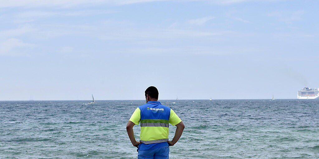 Können einem den Badespass schnell einmal verderben: Ein Helfer hält am Strand El Molinar in Palma des Mallorca Ausschau nach Portugiesischen Galeeren.