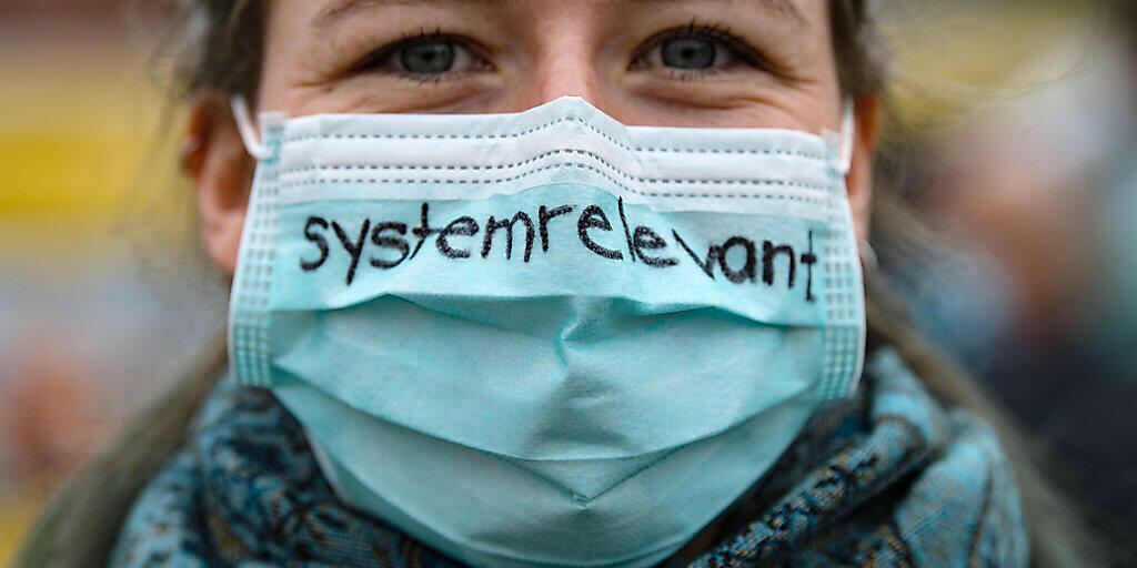 Keine Maskensünderin: Eine Krankenschwester trägt einen Mund-Nasenschutz mit der Aufschrift "systemrelevant" - dem Deutschschweizer Wort des Jahres 2020. (Archivbild) Keine Maskensünderin: Eine Krankenschwester trägt einen Mund-Nasenschutz mit der Aufschrift "systemrelevant" - dem Deutschschweizer Wort des Jahres 2020. (Archivbild)