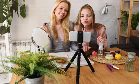 Mother and daughter influencers advertizing natural cosmetics and make up on social media together at home