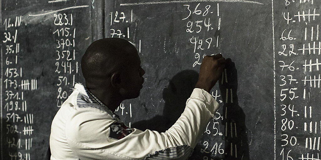 Ein Wahlmitarbeiter bei der Stimmenauswertung in einem Urnenlokal in Kinshasa. (Archivbild)