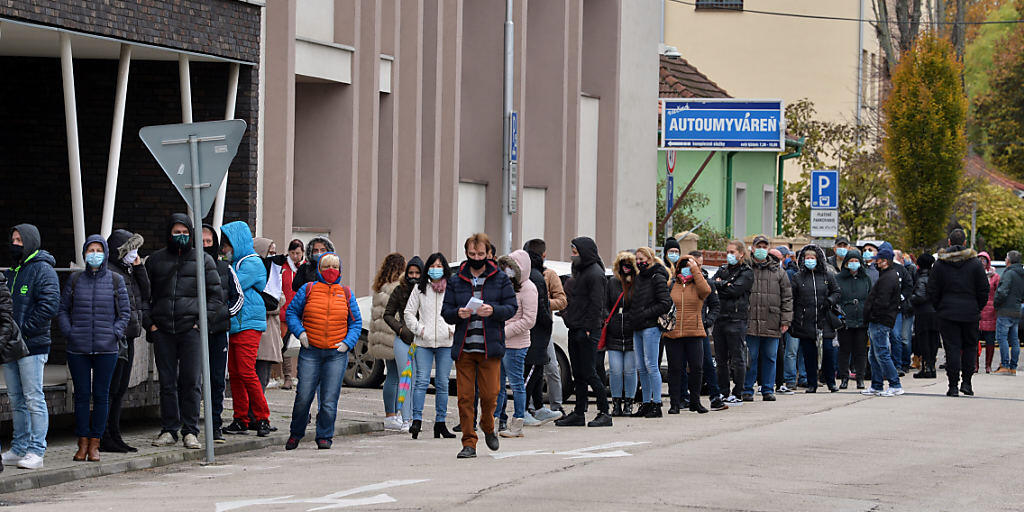 Zahlreiche Menschen mit Gesichtsmaske warten in einer Schlange, um sich auf das Coronavirus testen zu lassen. Foto: Edmund ÷rzsik/TASR/dpa Zahlreiche Menschen mit Gesichtsmaske warten in einer Schlange, um sich auf das Coronavirus testen zu lassen. Foto: Edmund ÷rzsik/TASR/dpa