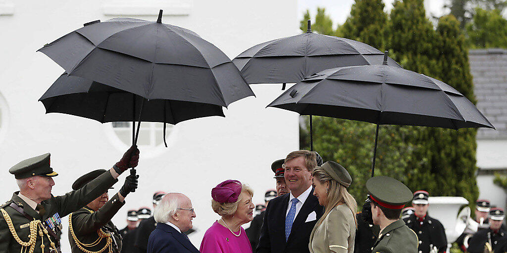 Empfang unterm Regenschirm: Irlands Präsident Michael Higgins (dritter von links) und seine Frau Sabina Coyne begrüssen das niederländische Königspaar Willem-Alexander und Máxima in Dublin.