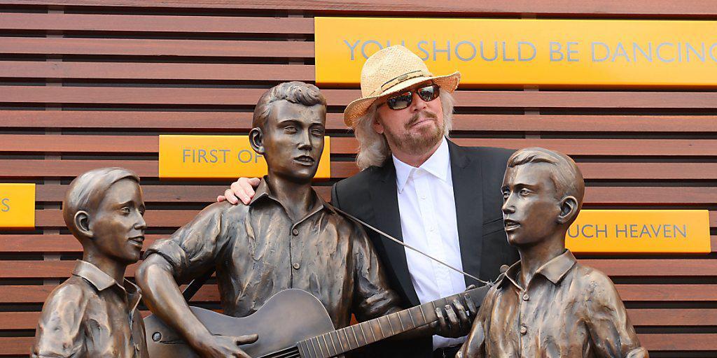 Barry Gibb mit einer Statue, die ihn und seine beiden kleinen Brüder als die jungen Bee Gees zigt. (Archivbild)