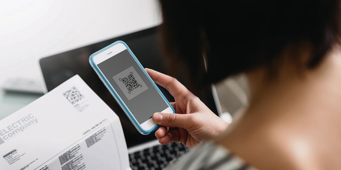 Woman paying bills with her smartphone