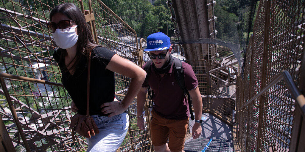 Touristen steigen eine Treppe des Eiffelturms empor. Nach einer über dreimonatigen Zwangspause wegen der Corona-Krise hat der Pariser Eiffelturm am Donnerstag seine Pforten wieder geöffnet. Besucher können zunächst nur über die Treppen den zweiten Stock des Turms erreichen, die Aufzüge sollen erst vom 1. Juli an wieder öffnen. Foto: Andreina Flores/SOPA Images via ZUMA Wire/dpa Touristen steigen eine Treppe des Eiffelturms empor. Nach einer über dreimonatigen Zwangspause wegen der Corona-Krise hat der Pariser Eiffelturm am Donnerstag seine Pforten wieder geöffnet. Besucher können zunächst nur über die Treppen den zweiten Stock des Turms erreichen, die Aufzüge sollen erst vom 1. Juli an wieder öffnen. Foto: Andreina Flores/SOPA Images via ZUMA Wire/dpa