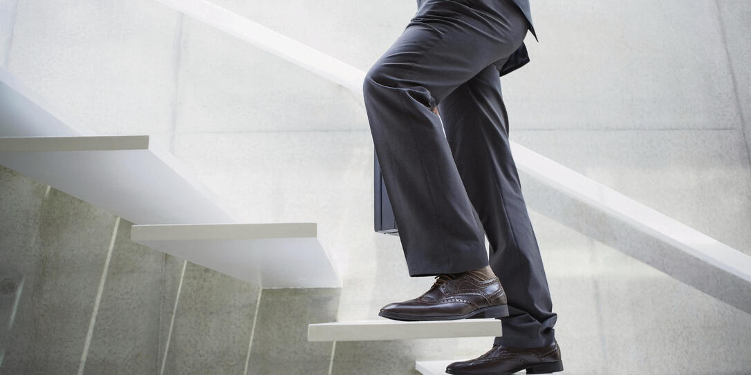 Businessman walking up the stairs in the hallway