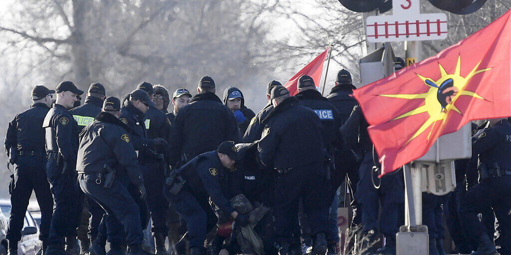 Polizisten in Ontario tragen Demonstranten von den Schienen. (Foto: Adrian Wyld/AP Keystone-SDA)