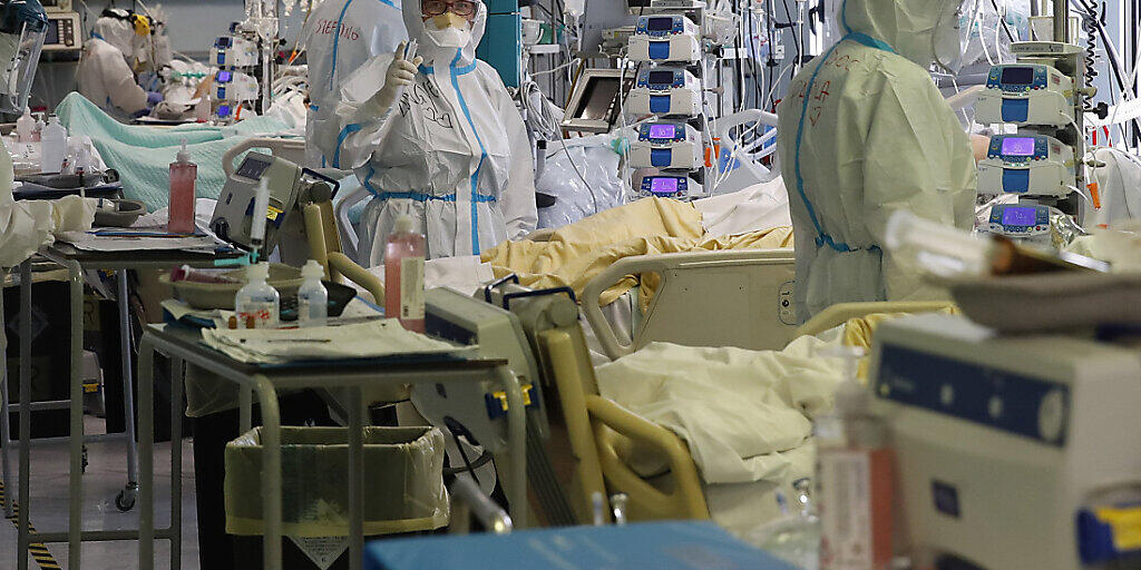 Medizinisches Personal in Schutzkleidung behandelt Patienten auf der Intensivstation des Krankenhaus San Filippo Neri. Foto: Alessandra Tarantino/AP/dpa Medizinisches Personal in Schutzkleidung behandelt Patienten auf der Intensivstation des Krankenhaus San Filippo Neri. Foto: Alessandra Tarantino/AP/dpa