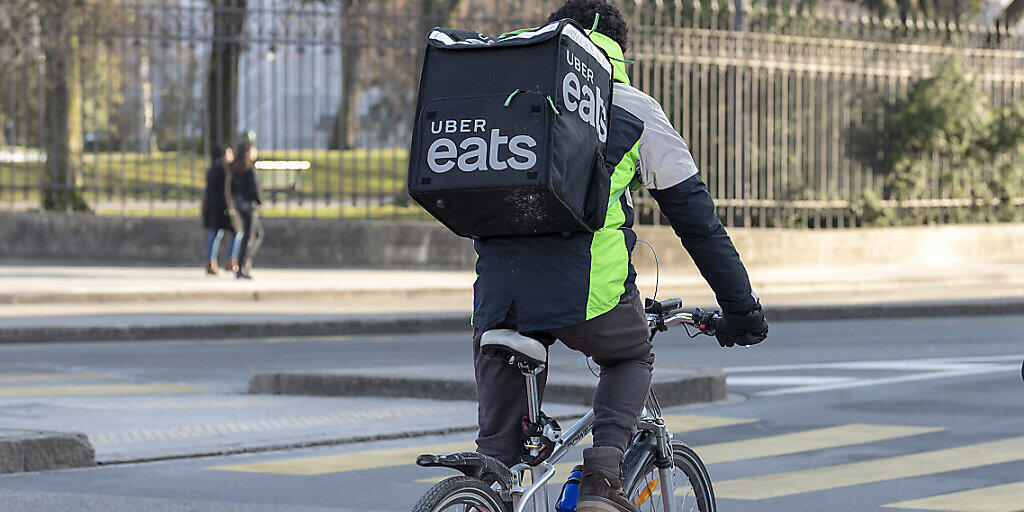 Ein Uber-Velokurier liefert in Genf online bestelltes Essen an einen Kunden aus. (Archivbild)