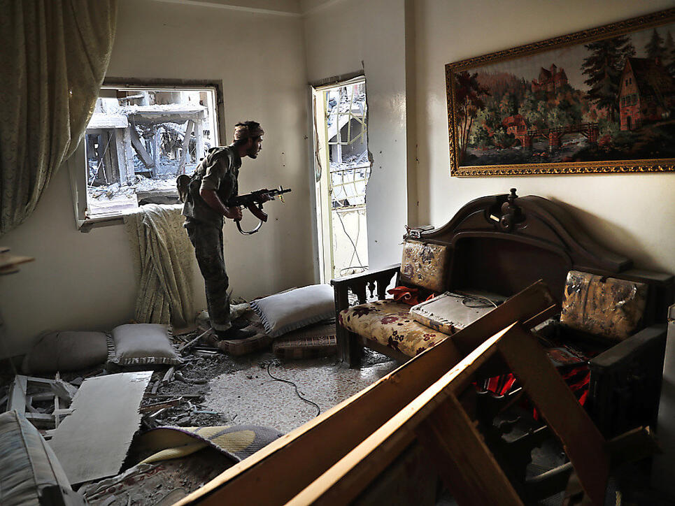 Ein Kämpfer des SDF bringt sich in einer zerstörten Wohnung an der Frontlinie in der umkämpfen Stadt Rakka in Stellung gegen die Kämpfer des IS. (Archivbild)