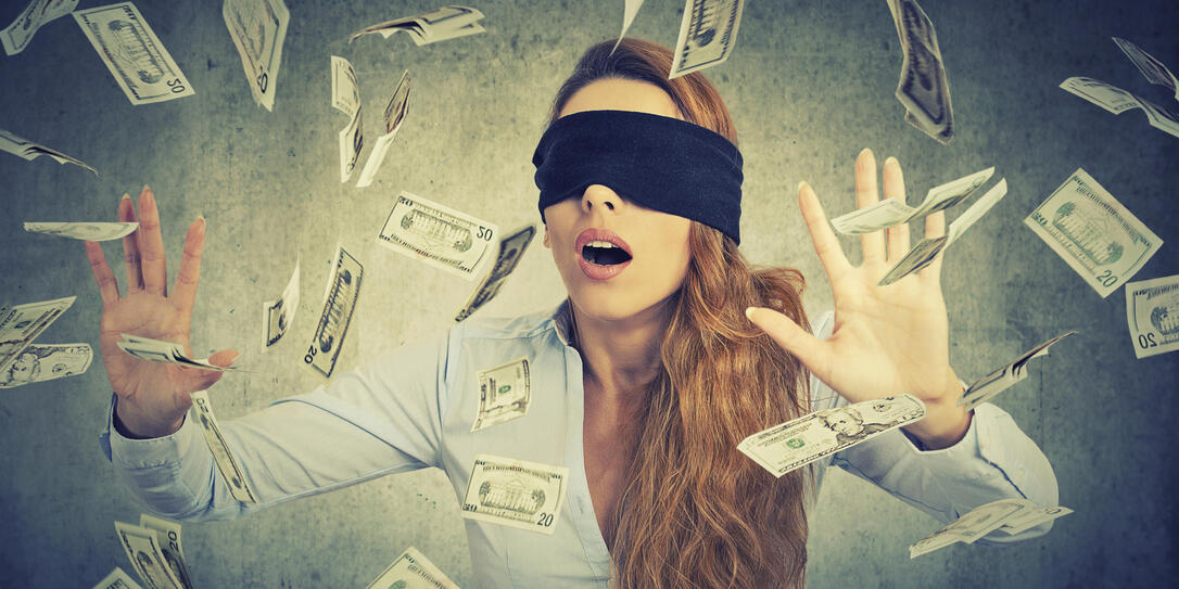 Blindfolded young entrepreneur businesswoman trying to catch do