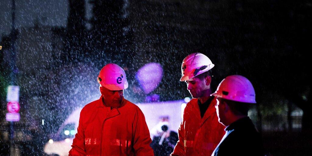 Mitarbeiter einer Energiefirma bei der Arbeit im Regen in der argentinischen Hauptstadt Buenos Aires. Mitarbeiter einer Energiefirma bei der Arbeit im Regen in der argentinischen Hauptstadt Buenos Aires.