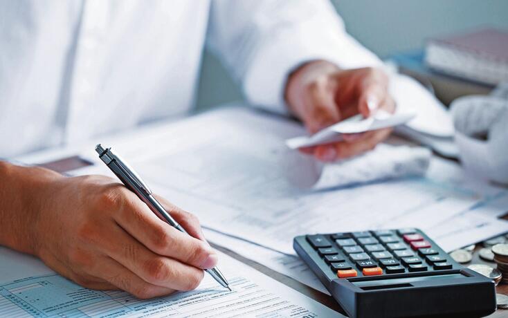 Man hand filling US tax form. tax form us business income office Financial document. Tax time.Tax concept. Close-up.