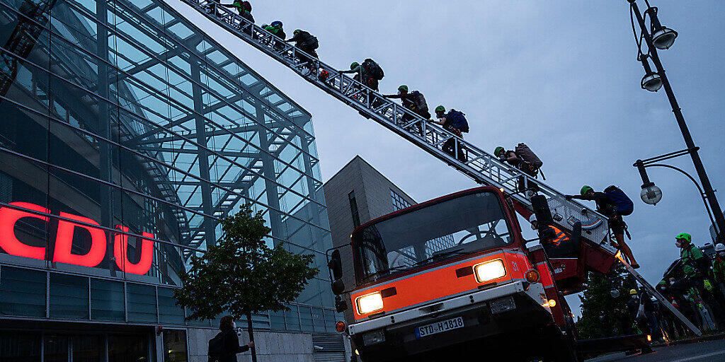 dpatopbilder - Greenpeace-Aktivisten klettern am frühen Morgen auf das Dach der CDU-Parteizentrale. Die Organisation demonstriert mit der Aktion für den Kohleausstieg. Foto: Christophe Gateau/dpa