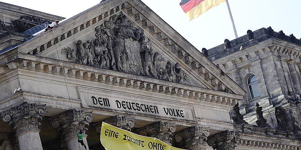 Greenpeace-Aktivisten seilen sich mit einem Transparent vom Reichstagsgebäude ab, auf dem geschrieben steht: «Eine Zukunft ohne Kohlekraft». Der Bundestag verabschiedet heute ein neues Kohlegesetz. Foto: Kay Nietfeld/dpa Greenpeace-Aktivisten seilen sich mit einem Transparent vom Reichstagsgebäude ab, auf dem geschrieben steht: «Eine Zukunft ohne Kohlekraft». Der Bundestag verabschiedet heute ein neues Kohlegesetz. Foto: Kay Nietfeld/dpa