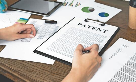 Business woman signs a patent. Intellectual property protection concept. Patent attorney.