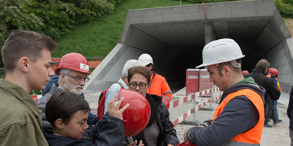 Besucher mit Schutzhelmen machen sich am Tunnelportal des Ceneri-Basistunnels bereit für die Besichtigung.