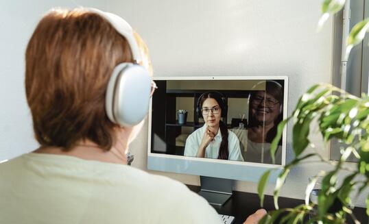 Senior adult plus size woman having online psychotherapy session with professional psychologist using computer at home. Digital service business