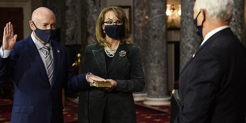 Der demokratische Senator Mark Kelly (l), Arizona, und seine Frau, die ehemalige Abgeordnete Gabby Giffords, nehmen an einer Nachstellung seiner Vereidigung durch Vizepräsident Mike Pence in der alten Senatskammer auf dem Capitol Hill in Washington teil. Foto: Nicholas Kamm/POOL AFP/dpa